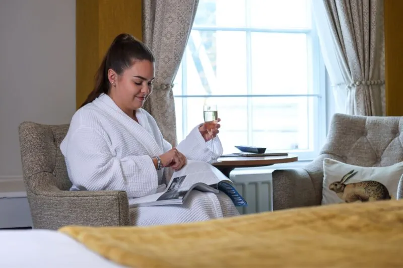 The Queens Hotel Cheltenham guest reading a magazine with Prosecco