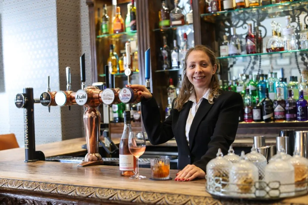 The Queens Hotel Cheltenham waitress at the bar