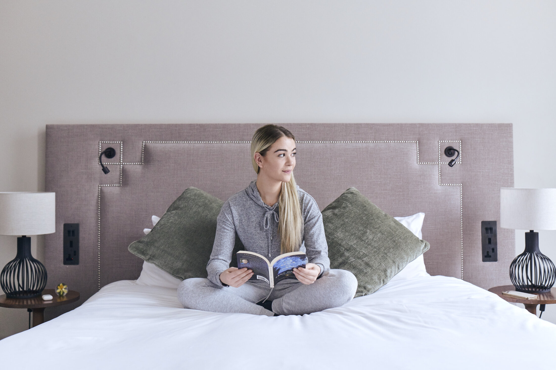 a woman reading a book in bed