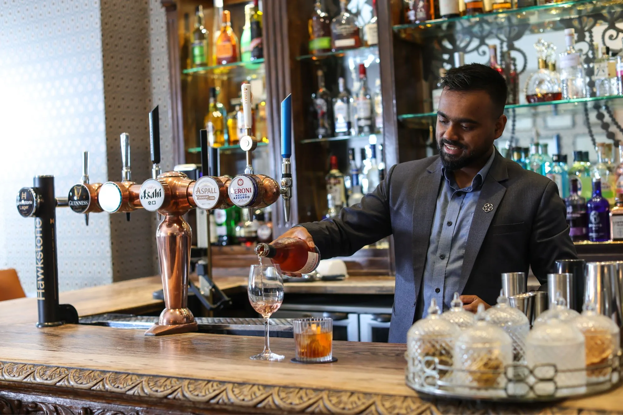 The Queens Hotel Cheltenham bar man pouring wine